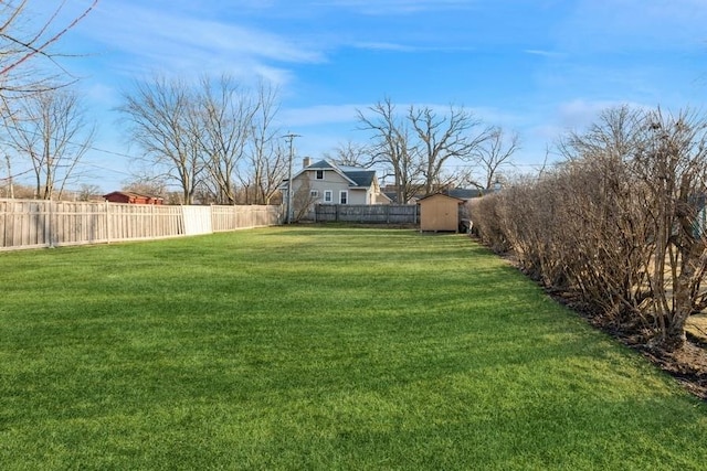 view of yard featuring a shed, an outdoor structure, and a fenced backyard