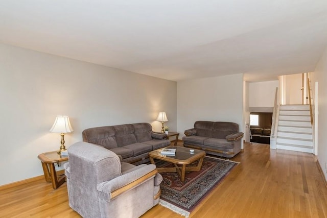 living area featuring light wood-style flooring and stairway