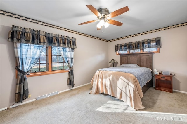 carpeted bedroom with ceiling fan, visible vents, and baseboards