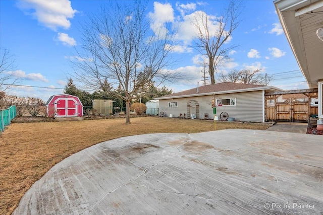 view of yard with fence, an outdoor structure, and a shed