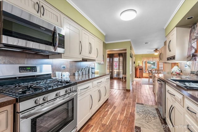 kitchen featuring dark countertops, stainless steel appliances, and crown molding