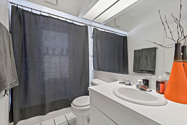 bathroom with curtained shower, tile patterned flooring, toilet, vanity, and tile walls