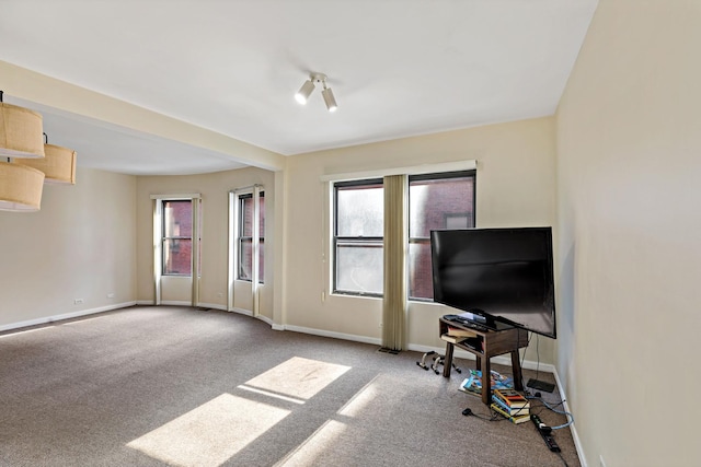 carpeted living room featuring baseboards