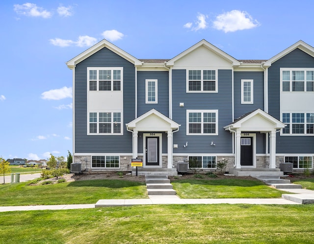 view of front facade with stone siding, a front lawn, and cooling unit