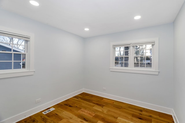 spare room featuring visible vents, baseboards, wood finished floors, and recessed lighting