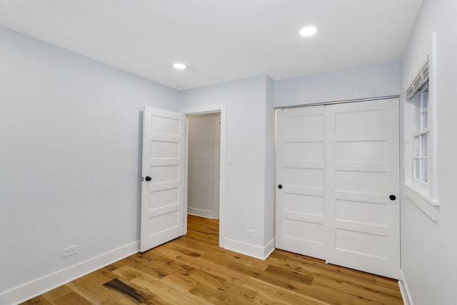 unfurnished bedroom featuring recessed lighting, wood finished floors, and baseboards