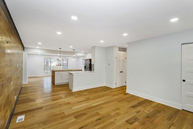 unfurnished living room featuring light wood finished floors, baseboards, visible vents, and recessed lighting