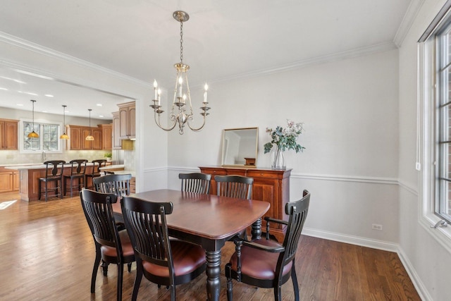 dining area with ornamental molding, an inviting chandelier, baseboards, and wood finished floors