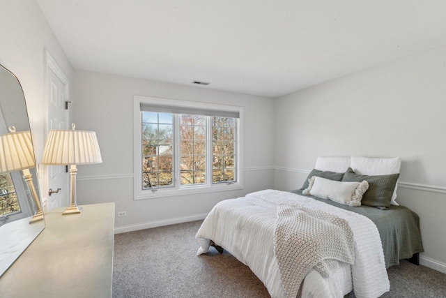 carpeted bedroom featuring visible vents and baseboards