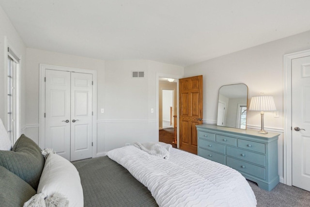 bedroom with carpet floors, visible vents, and a closet