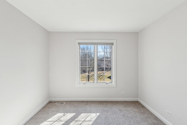 unfurnished room with baseboards, visible vents, and light colored carpet