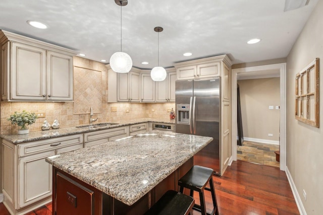 kitchen with tasteful backsplash, cream cabinetry, a sink, and stainless steel fridge with ice dispenser