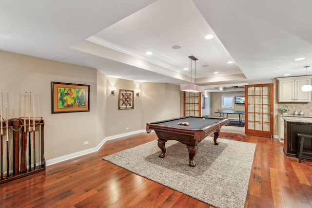 playroom with a tray ceiling, billiards, hardwood / wood-style floors, and baseboards