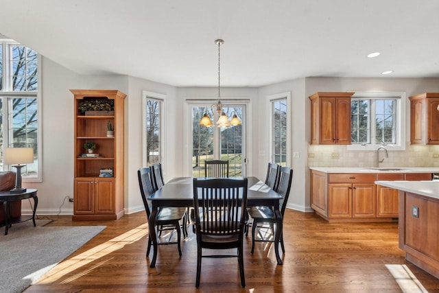 dining space featuring baseboards, dark wood-style flooring, recessed lighting, and a notable chandelier