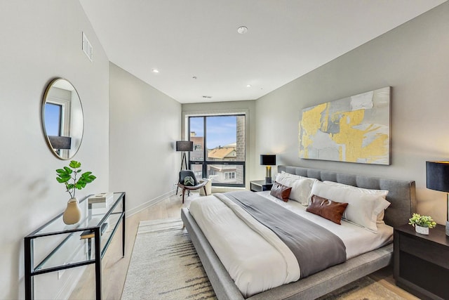 bedroom with visible vents, baseboards, and wood finished floors