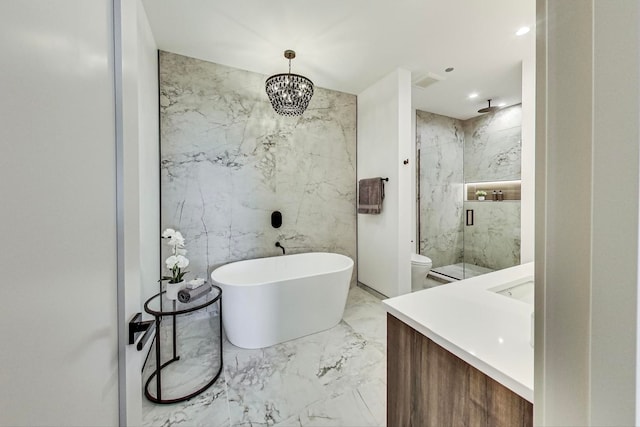 full bathroom featuring marble finish floor, a marble finish shower, vanity, a freestanding tub, and stone wall