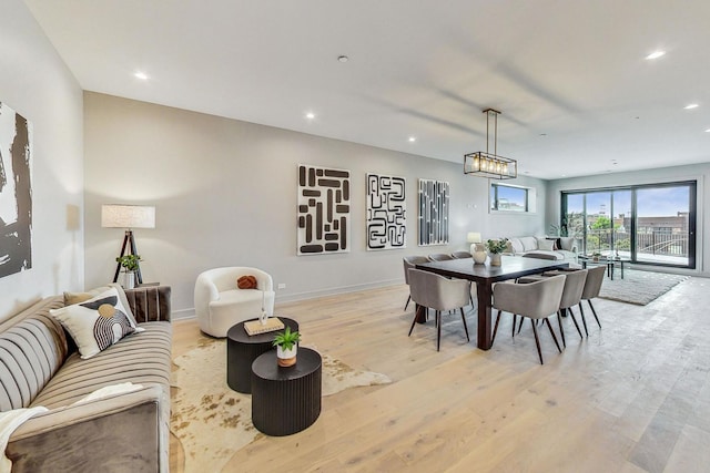 dining room with baseboards, light wood finished floors, and recessed lighting