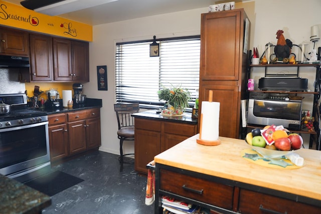 kitchen with stainless steel gas stove, butcher block countertops, and extractor fan