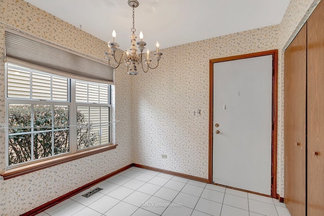 unfurnished dining area featuring wallpapered walls, light tile patterned floors, baseboards, visible vents, and a chandelier