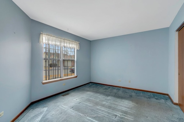 carpeted spare room with baseboards and visible vents