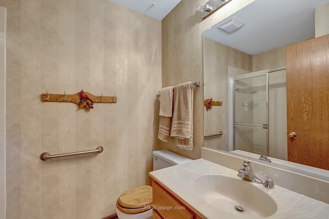 bathroom with toilet, vanity, a shower stall, and visible vents