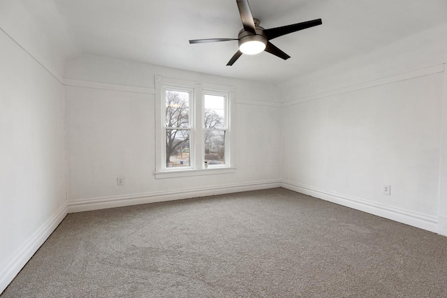 carpeted spare room featuring a ceiling fan and baseboards