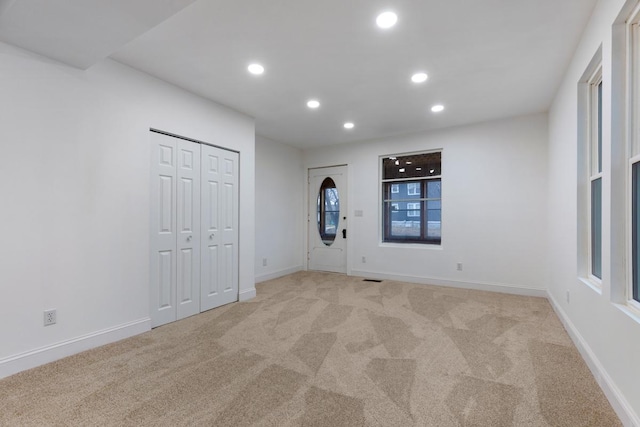 spare room with recessed lighting, baseboards, and light colored carpet