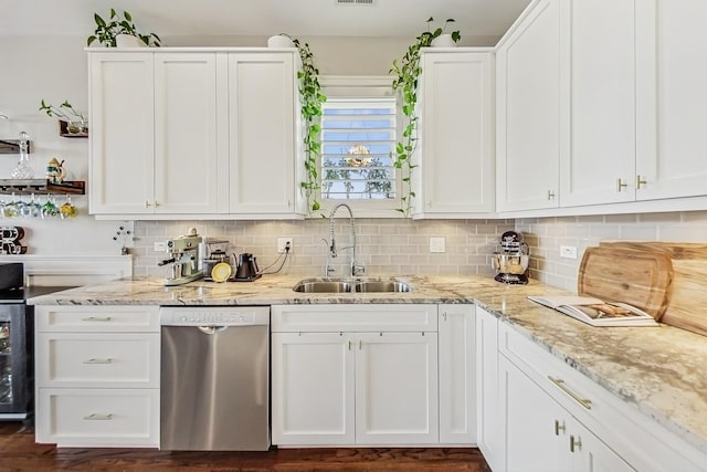 kitchen featuring a sink, white cabinetry, decorative backsplash, and dishwasher