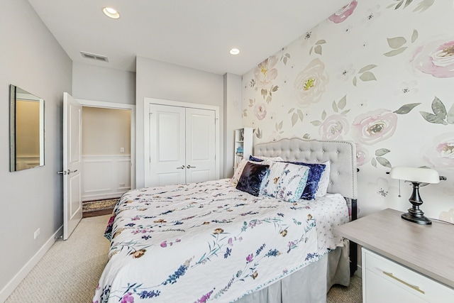 bedroom with recessed lighting, a closet, light carpet, and visible vents