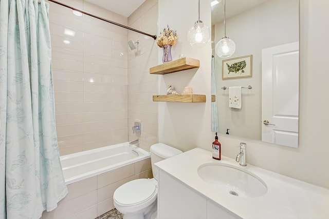 bathroom with tiled shower / bath combo, vanity, and toilet