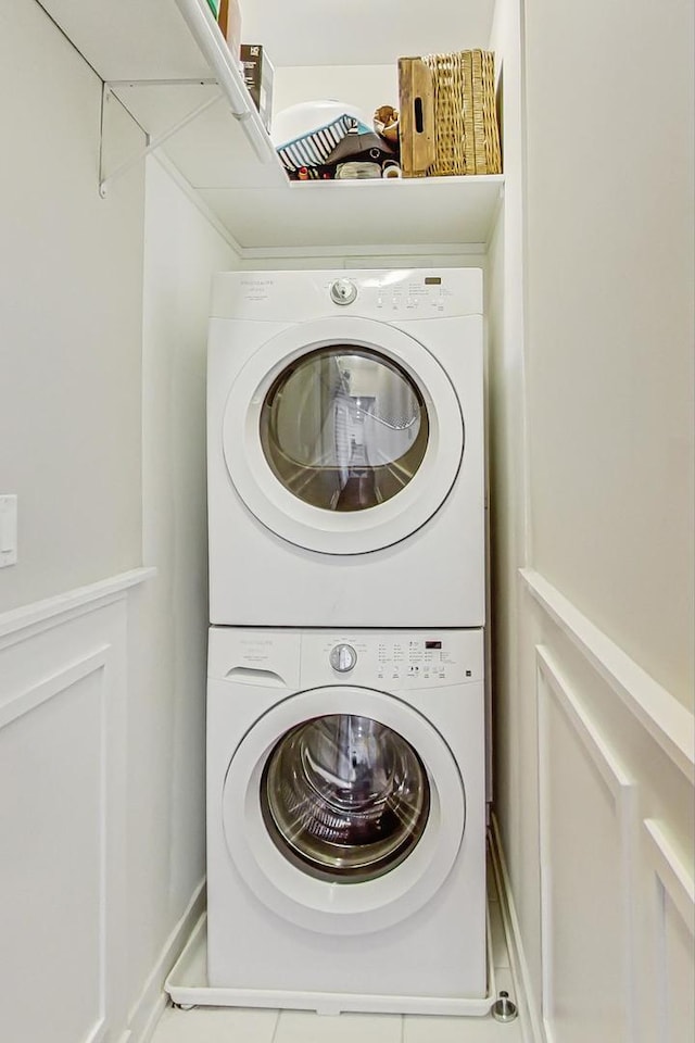 washroom with stacked washer and dryer and laundry area