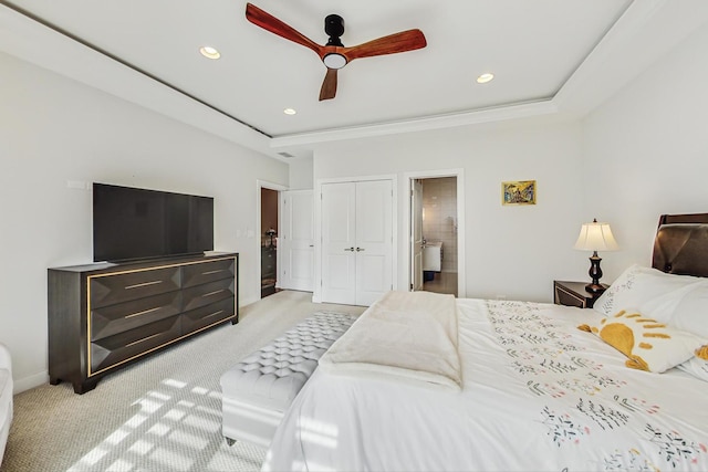 carpeted bedroom with a closet, recessed lighting, a raised ceiling, and ceiling fan