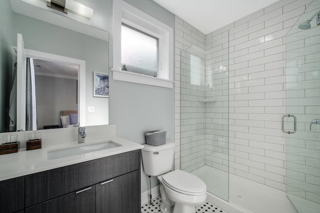 ensuite bathroom featuring ensuite bathroom, toilet, vanity, a shower stall, and tile patterned floors