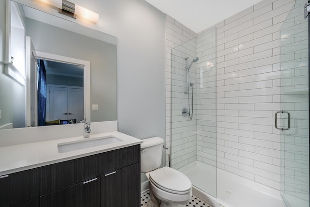 full bath featuring toilet, a shower stall, and vanity