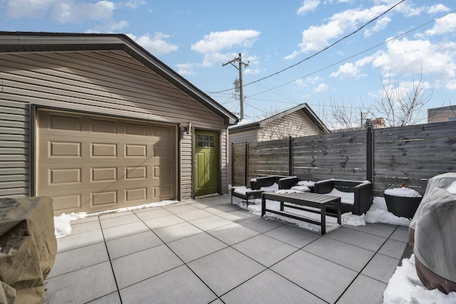 view of patio with a garage, an outbuilding, fence, and driveway