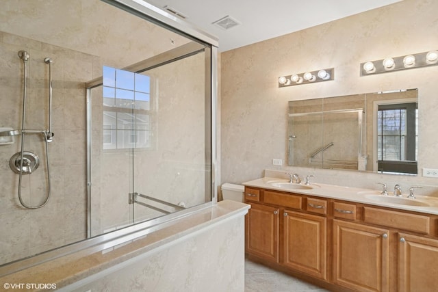 full bathroom with double vanity, visible vents, a sink, and tiled shower