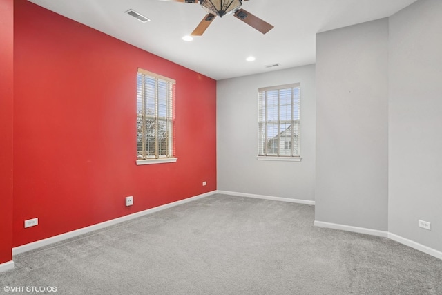 unfurnished room with carpet floors, baseboards, visible vents, and ceiling fan