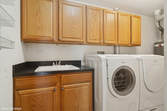 clothes washing area featuring cabinet space, a sink, and washing machine and clothes dryer