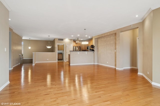 unfurnished living room with baseboards, light wood-style flooring, visible vents, and crown molding