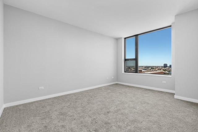 spare room with carpet and baseboards