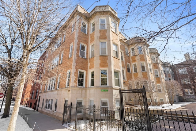 snow covered property with a fenced front yard