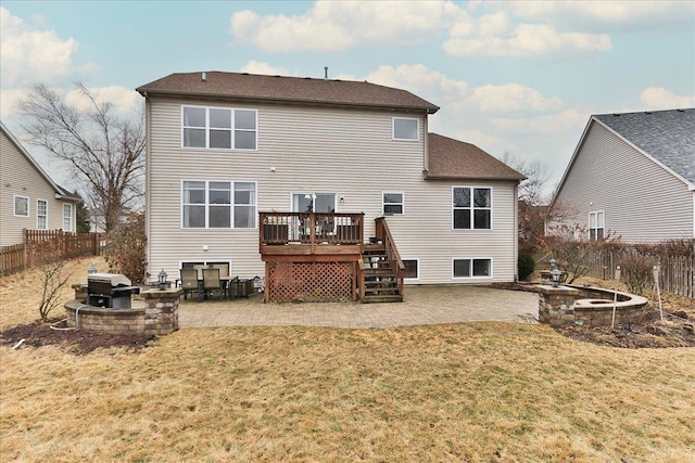 back of property featuring a deck, a patio area, a lawn, and a fenced backyard