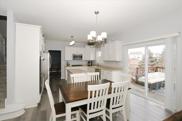 dining room with an inviting chandelier, visible vents, and wood finished floors