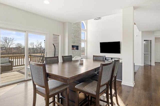 dining area with recessed lighting, a fireplace, dark wood finished floors, and baseboards