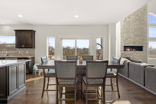 dining space featuring a fireplace, dark wood finished floors, and recessed lighting