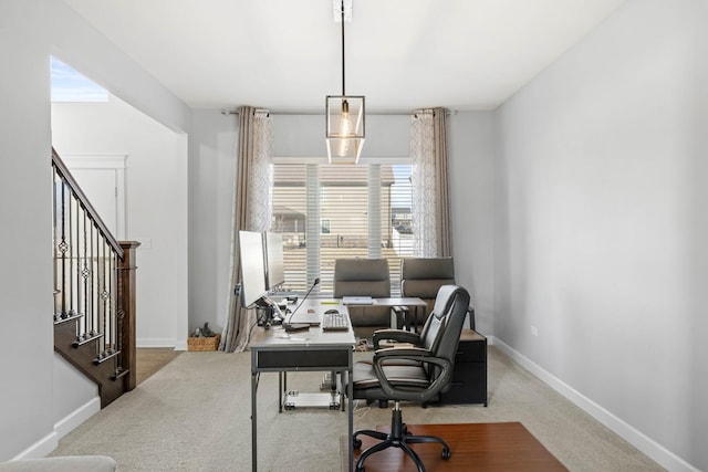 carpeted office space featuring baseboards