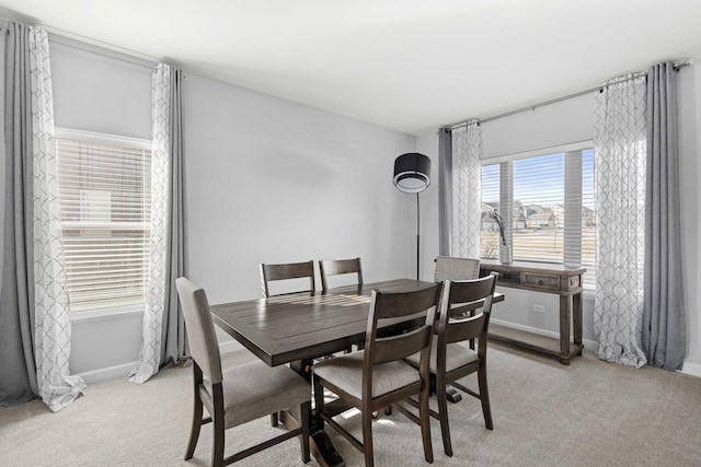 dining area with light colored carpet and baseboards