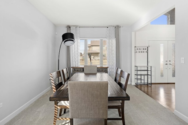 dining room with dark wood-style flooring, french doors, and baseboards