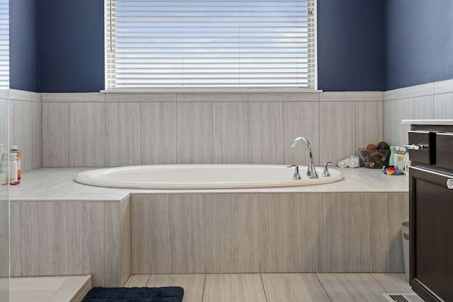 full bath with a garden tub and a wealth of natural light