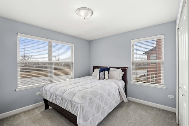 bedroom with light carpet and baseboards